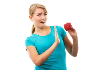 Disgusted woman holding old wrinkled peppers, unhealthy eating