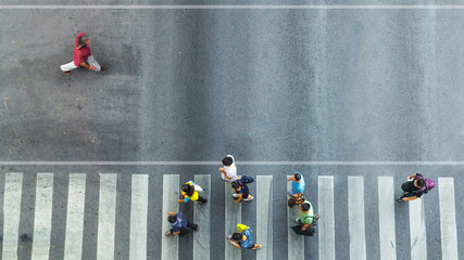 the one man walk converse,  the busy city crowd move to pedestrian crosswalk on businees traffric road (Aerial photo, top view)