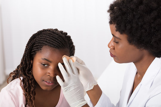 Doctor Applying Band Aid To Girl Head