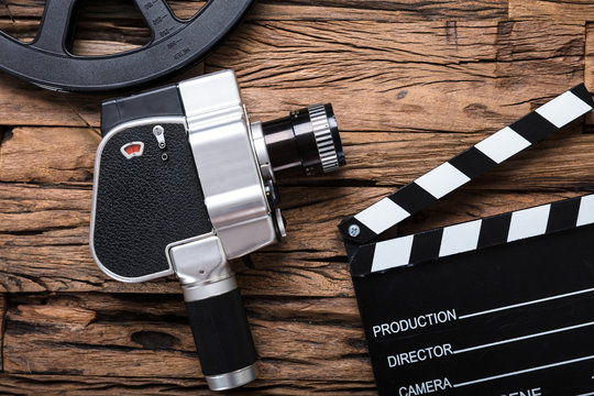 Movie Camera With Film Reel And Clapper Board On Wood