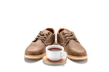 Coffee cup being at the center brown shoes