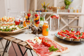 Food table with healthy delicious organic meal concept. People friends celebrate and eat healthy organic meals at served festive wooden table served for party.