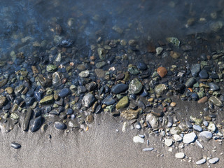 Detail of a river shoreline with many pebbles, Alaska, USA