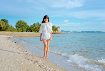Fototapeta na wymiar Young woman walking along the beach