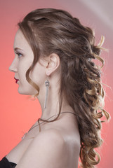 Demonstration of hairstyles Greek braid in profile. Isolated pink background.