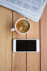 cup of coffee with smartphone and newspaper on the table in the morning