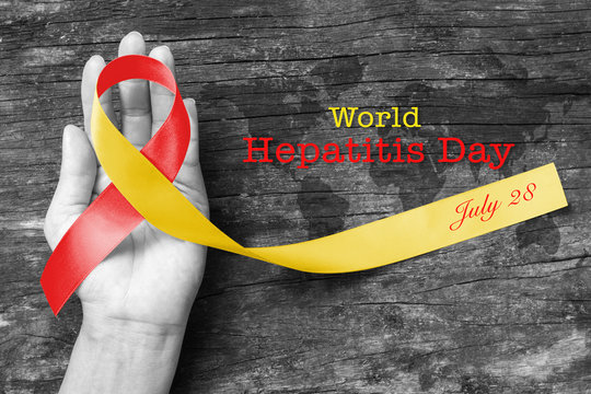 World hepatitis day awareness with red yellow ribbon  (isolated  with clipping path) on person's hand support and old aged wood