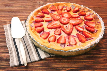 Tart with fresh strawberry on wooden background