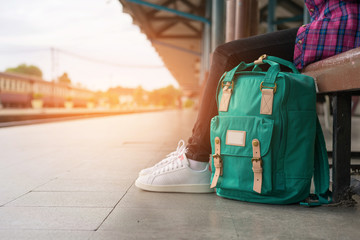 Fototapeta Young woman traveler and backpack waiting railway at train station, Young woman sitting with using smartphone at the train station, Summer holiday and travel concept, Sun light flare obraz