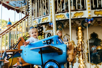 Fototapeta na wymiar Cute blond toddler baby boy on a carousel