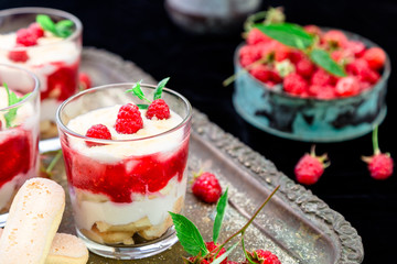 Tiramisu with raspberry in glasses on metal tray. Three portion. Italian dessert.