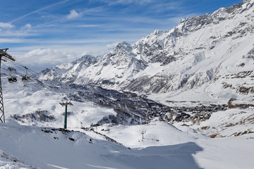 Fototapeta premium Mountain skiing - panoramic view at the ski slopes and Cervinia, Italy, Valle d'Aosta, Breuil-Cervinia, Aosta Valley, Cervinia
