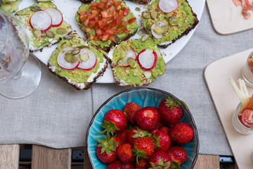 Food table with healthy delicious organic meal concept. People friends celebrate and eat healthy organic meals at served festive wooden table served for party.