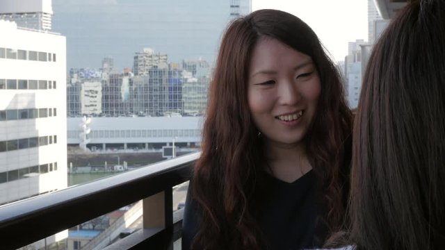 Japanese woman chatting on a balcony.