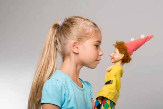 junges M&auml;dchen spielt mit der Handpuppe des Kaspers