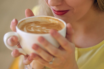 A girl drinks coffee to a cafe