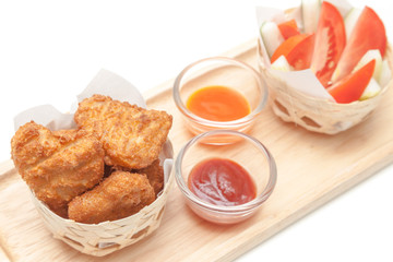 Fried chicken nuggets serve with tomato, cucumber and sauces