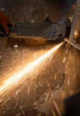 Worker cuts a metal pipe at a construction site