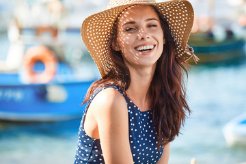 Portrait of a beautiful woman in a straw hat. Laughing girl. Summer time