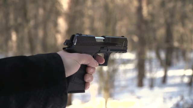 gun shot in slow motion. winter landscape man hand