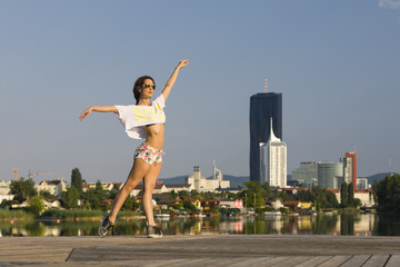 Fototapeta na wymiar Fit girl in shorts with a dancing pose at the river