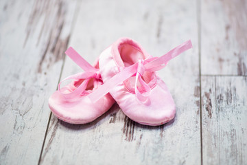 Children's pink shoes on a wooden background. Waiting for the girl.
