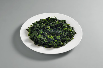 Round dish with a portion of boiled spinach