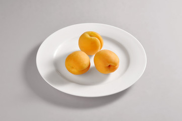 Round dish with three apricots