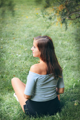 young beautiful happy woman sitting on the grass