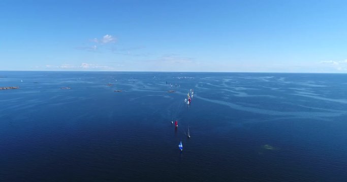 Sailboat regatta, Cinema 4k aerial rising tilt view of a lot of sailboats in the baltic sea and heading towards hanko city, out on the  finnish archipelago, turquoise sea, on hango regatta day