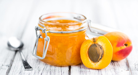 Portion of Apricot Jam on wooden background (selective focus)