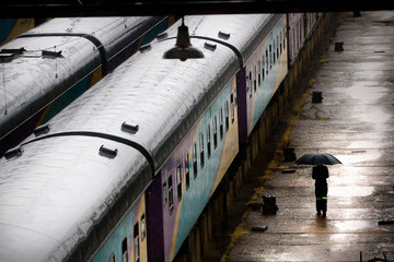 A man walks with an umbrella beside the Shosholoza Meyl train after a sudden downpour in Braamfontein, Johannesburg. Picture: DANIEL BORN