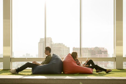 Couple Use Smartphone And Laptop In Afternoon, Technology Lifestyle Of New Generation Of Nomad Workers