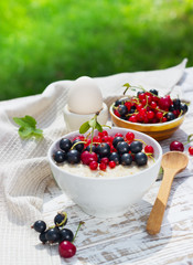 healthy breakfast - oatmeal with fresh berries in a bowl on white, fresh berries on the street