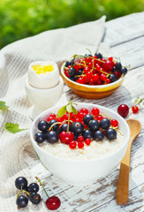 healthy breakfast - oatmeal with fresh berries in a bowl on white, fresh berries on the street