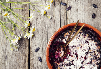 Honeysuckle clafoutis - traditional french berries pie, dessert on rustic wooden table. Selective focus. Toned image 