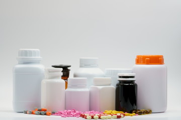 Pills and bottles with cap on white background