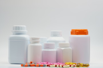 Pills and bottles with cap on white background