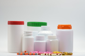 Pills and bottles with cap on white background