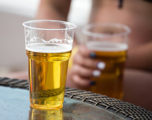 Beer in a plastic glass on the table