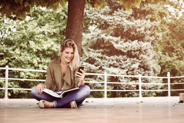Caucasian woman using mobile phone outdoor.