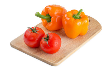 Pepper and tomato on wooden board