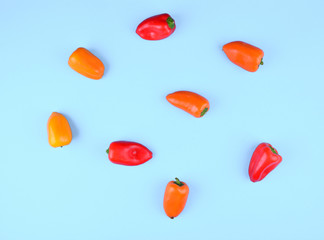 Red, orange, yellow paprika on blue background.