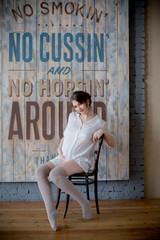 Naklejka na ściany i meble Portrait of a young pregnant woman in white shirt in photo Studio