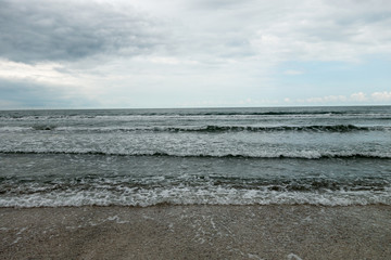 Landscape with sea view, waves and sea shells, clouds, photographed in Mamaia, Romania, in cloudy spring day