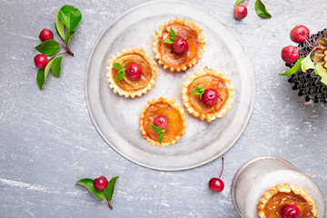 Apple caramel little tarts on grey background. French tatin with paradise apple. Top view.