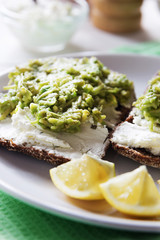 Avocado sandwich with cottage cheese and lemon close up