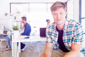 Young man sitting and looking at camera in office