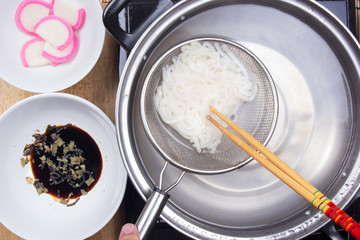 Chef scald udon noodle in pot