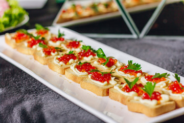 Canapе with red caviar in the buffet table